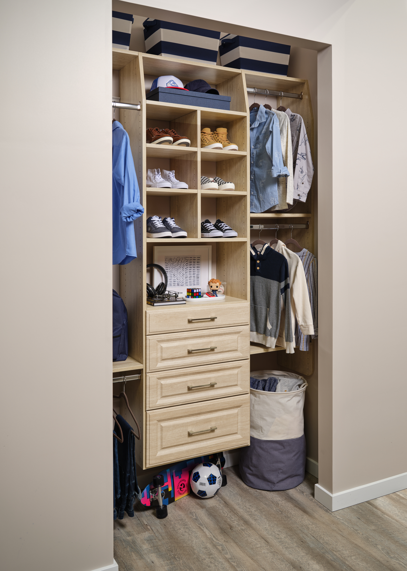 Reach-in closet for little boy with drawer and hanging storage from Inspired Closets