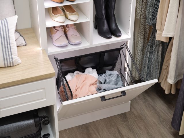 Women's white walk-in closet with pull out hamper and shoe shelves from Inspired Closets
