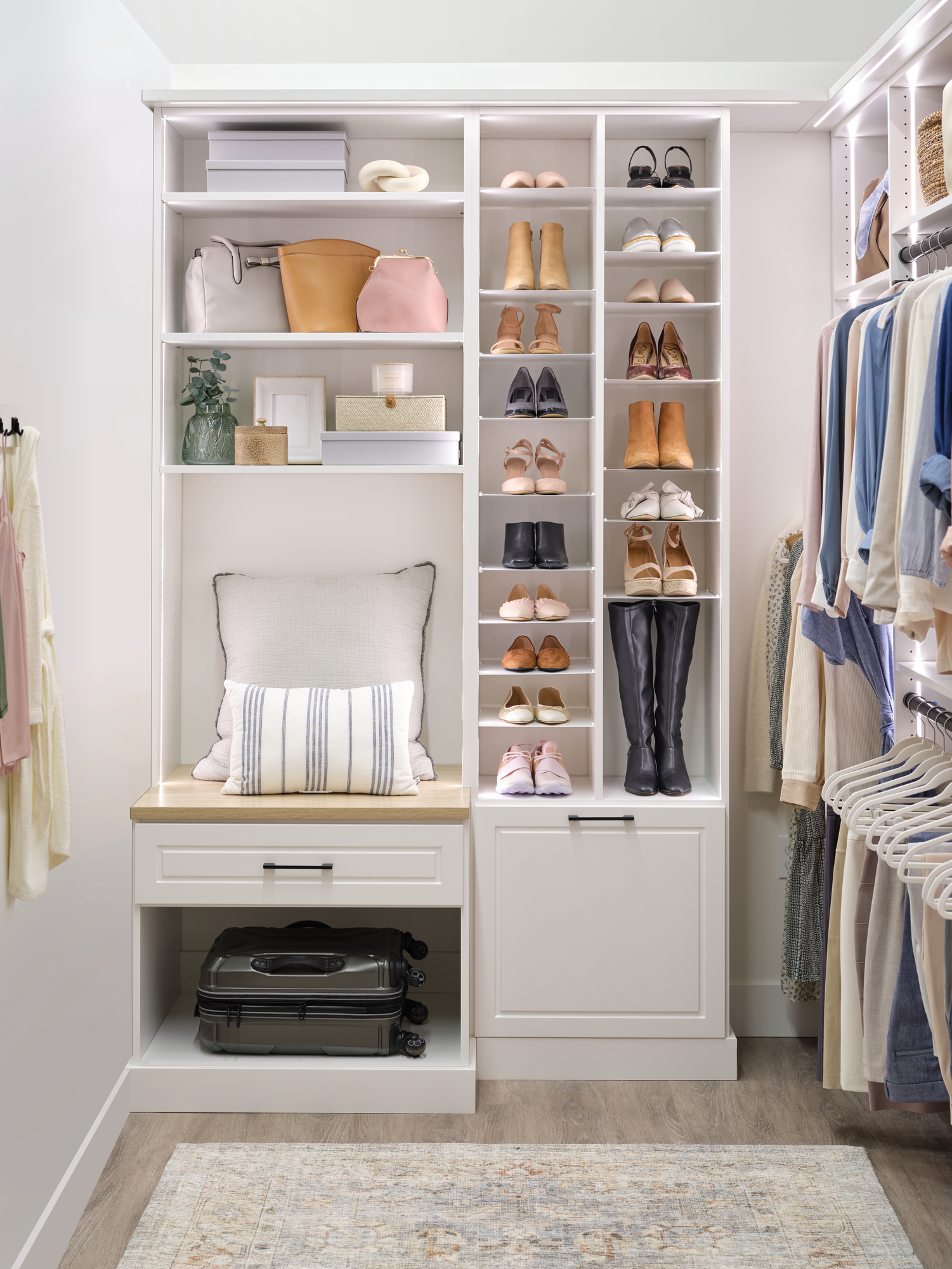 Bench seating for getting ready in a white women's walk-in closet from Inspired Closets