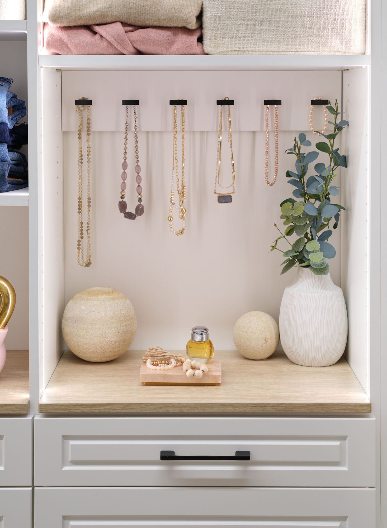 Unique storage for necklaces in a white walk-in closet from Inspired Closets