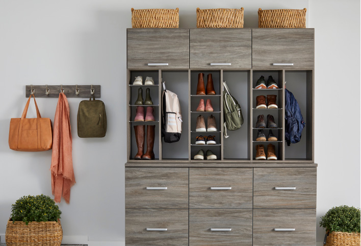A large shoe organizer with drawers stands next to a coat rack.