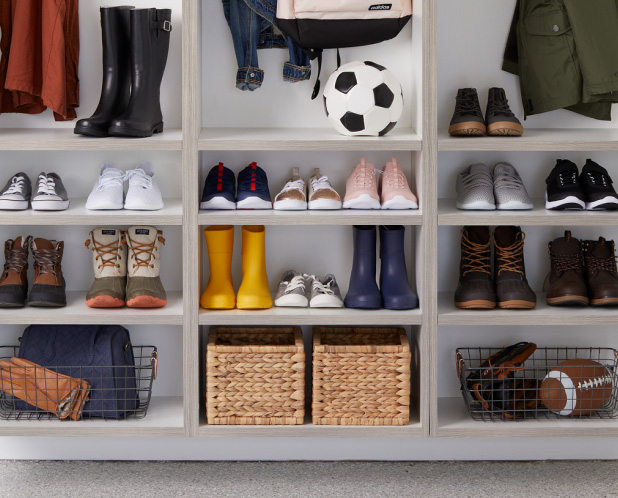 Shelves filled with shoes, sports balls, and coats.