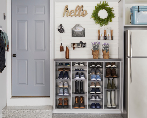 A shoe organizer sits by a door with the a sign reading hello.
