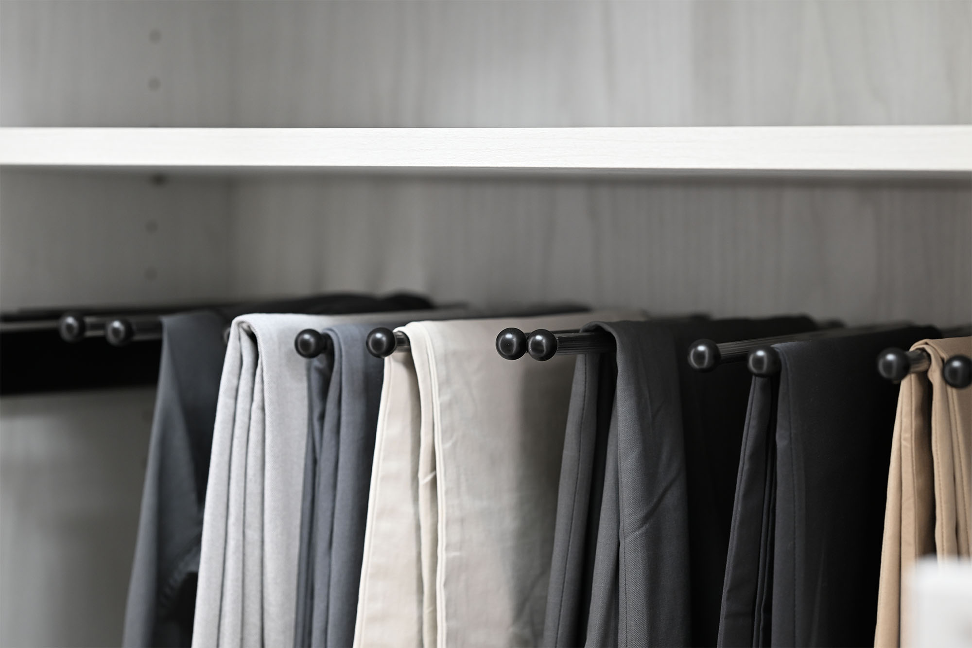 Men's pants storage hanging in boutique closet