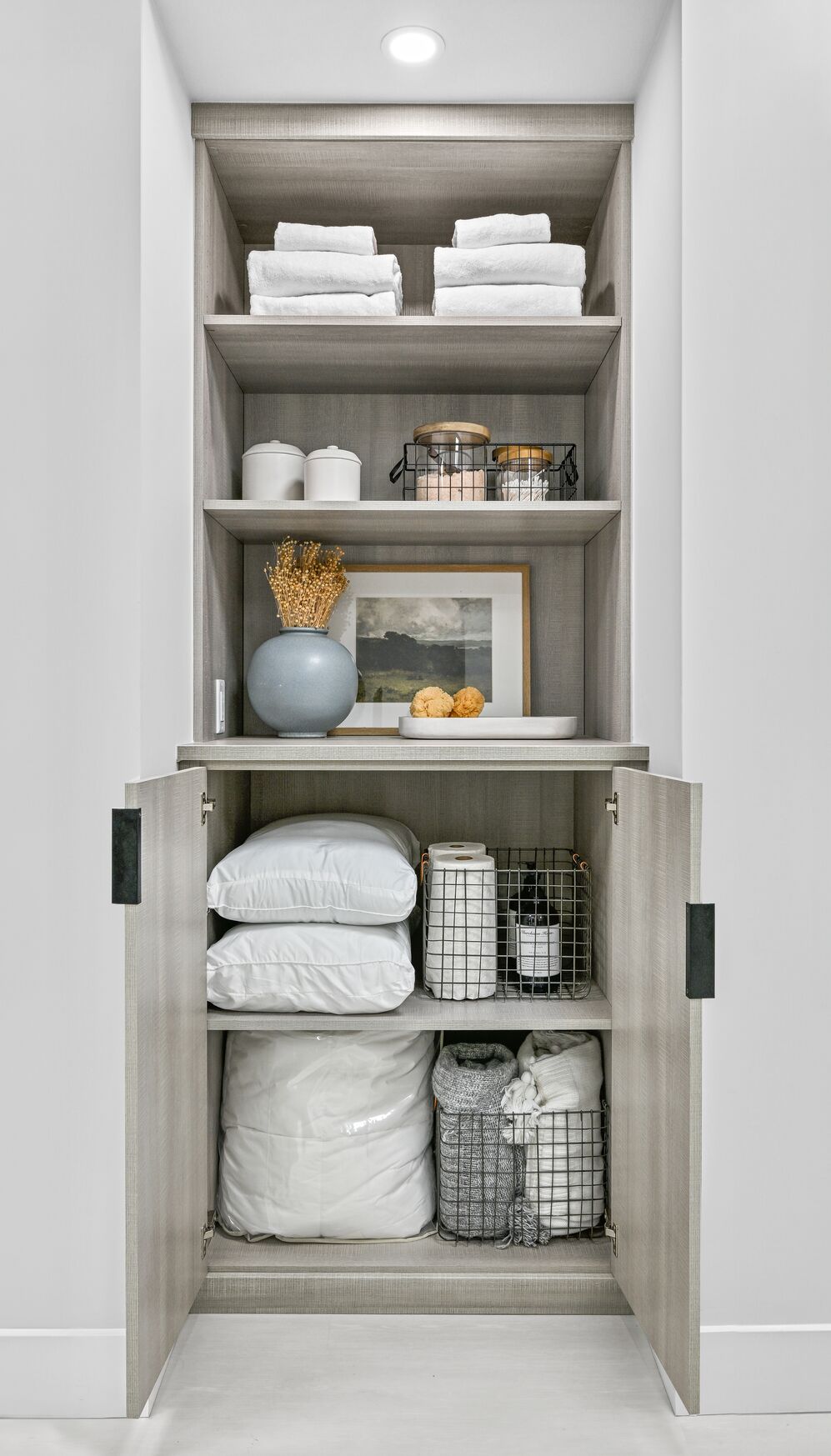 Hallway linen closet with pillow and bedding storage