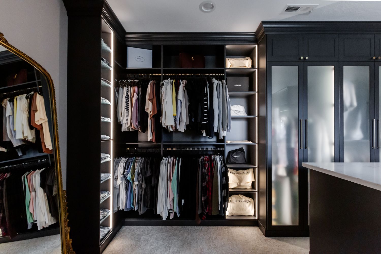 Organized jeans, tops, bottoms, and purses in an Inspired Closets boutique closet.
