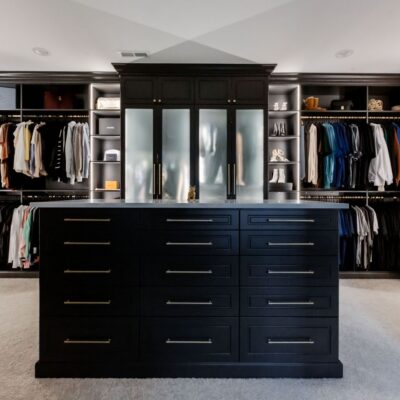 Custom island, Shoe Shrine, adjustable shelves, and glass doors included in this Inspired Closets boutique closet.