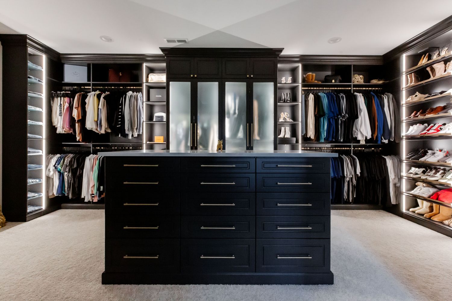 Custom island, Shoe Shrine, adjustable shelves, and glass doors included in this Inspired Closets boutique closet.
