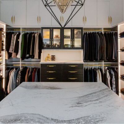 Glass display shelves and custom island in an Inspired Closets boutique closet.