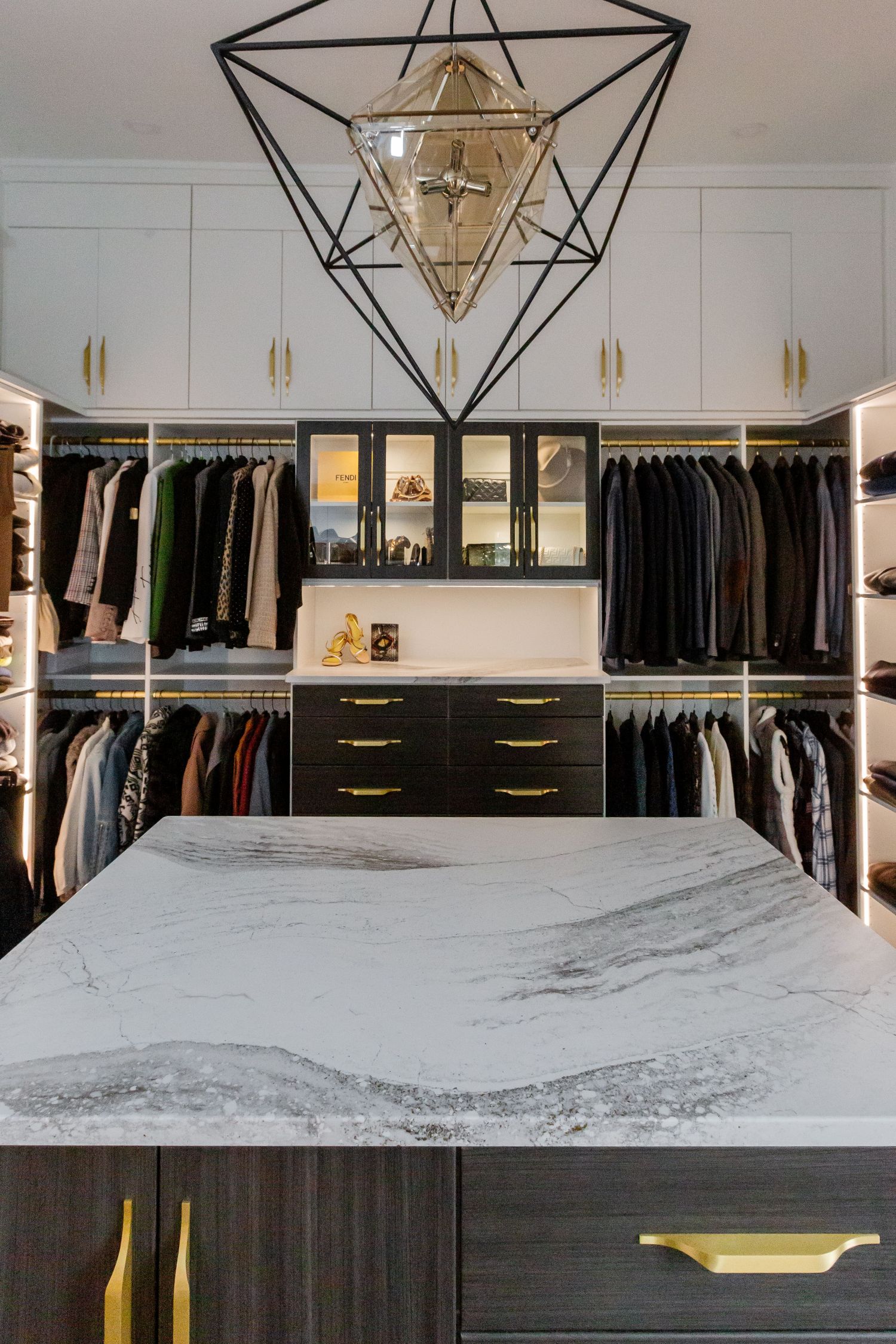 Glass display shelves and custom island in an Inspired Closets boutique closet.