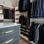 Matte brass hardware with a white and ore finish creates a beautiful Inspired Closets boutique closet.