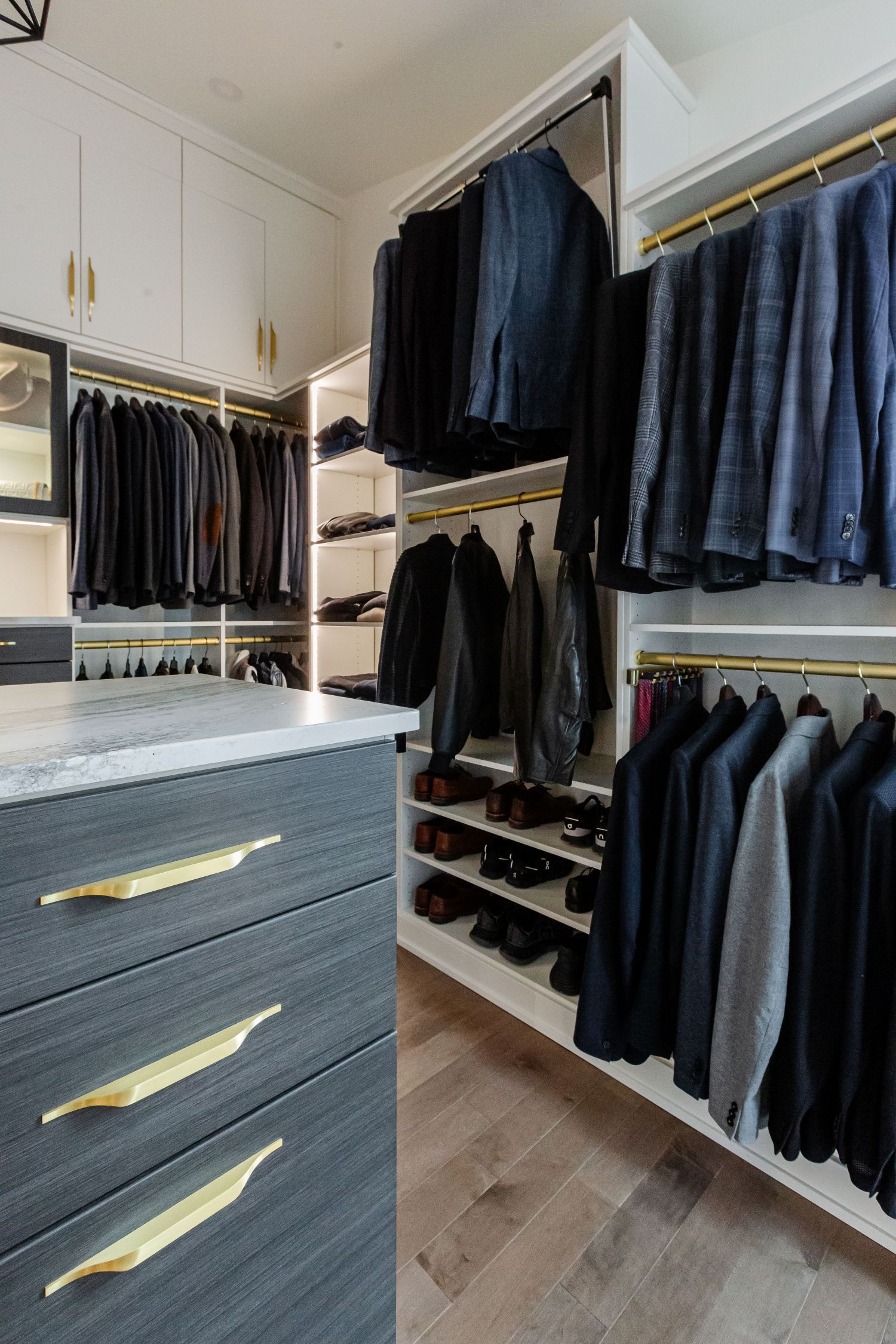 Matte brass hardware with a white and ore finish creates a beautiful Inspired Closets boutique closet.