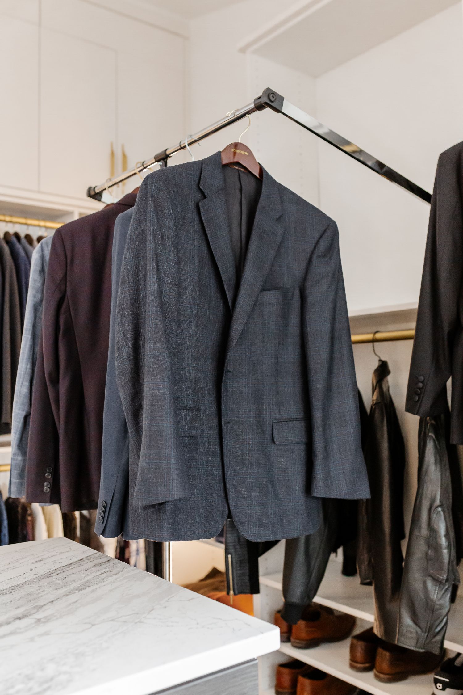 Pull-down hanging bar for suit jackets in an Inspired Closets boutique closet.