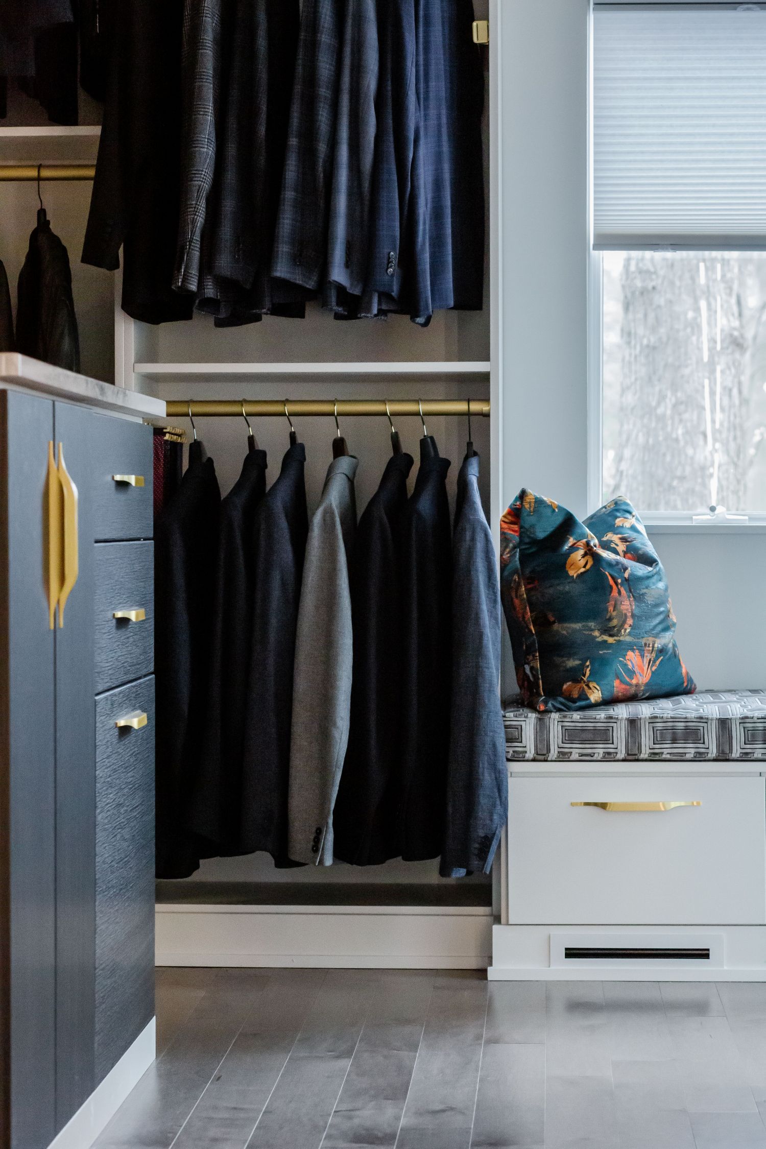 Ore, white, and matte brass hardware in a custom boutique Inspired Closets walk-in closet.