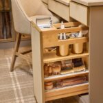 Close up of a custom vanity with a powered, pull-out drawer for beauty storage, leather drawer fronts, and matte brass and gold accents