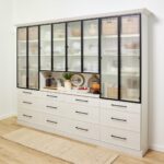 Custom hutch in a light wood-tone finish with matte black hardware, black-framed doors with reeded-glass fronts, and a prep counter in the center