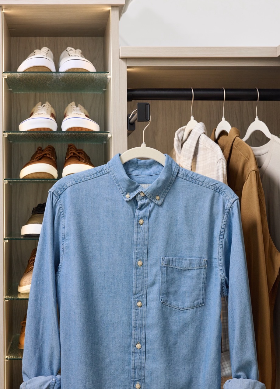 Detail of a closet valet rod with a hanging shirt and Shoe Shrine from Inspired Closets in a light wood tone finish