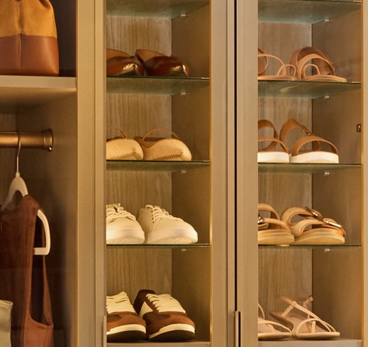A Shoe Shrine with a variety of a woman's shoes behind glass cabinet doors